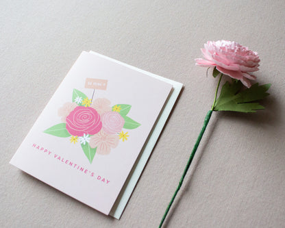 aesthetic shot of the be mine card and ranunculus flower